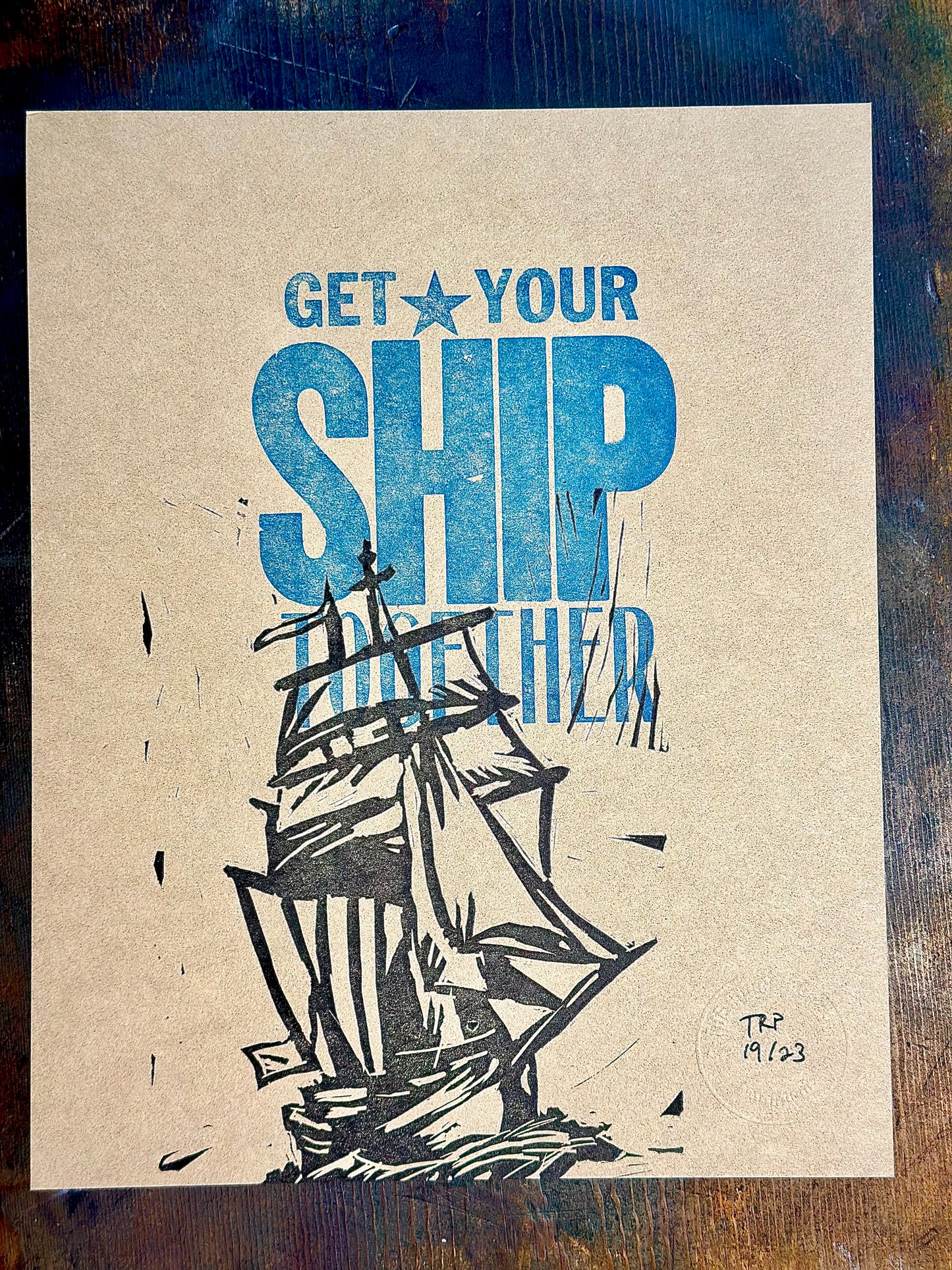 Get Your Ship Together - Handmade Letterpress Art print - Unframed View - on Kraft paper with our printing press in the background.