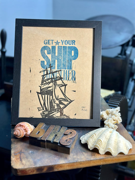 Get Your Ship Together - Handmade Letterpress Art print - Framed View - on Kraft paper with our printing press in the background.